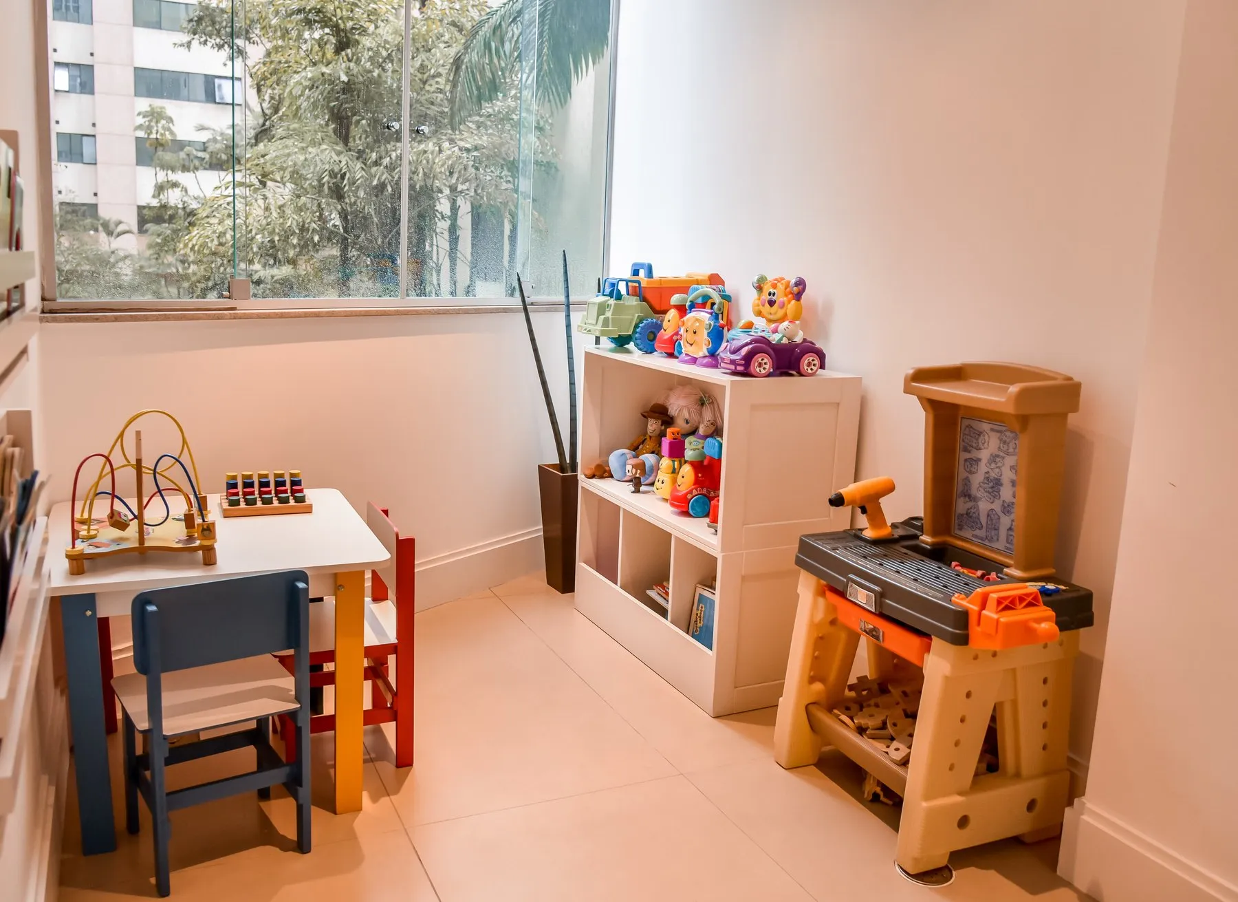 Espaço kids da clínica, com brinquedos, livros e mesinha colorida