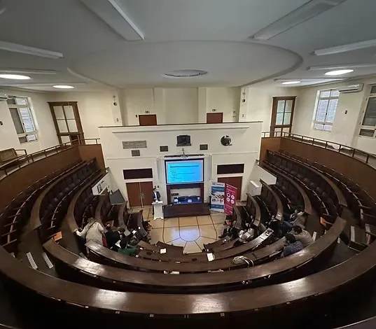 Anfiteatro histórico com a apresentação de uma aula no telão